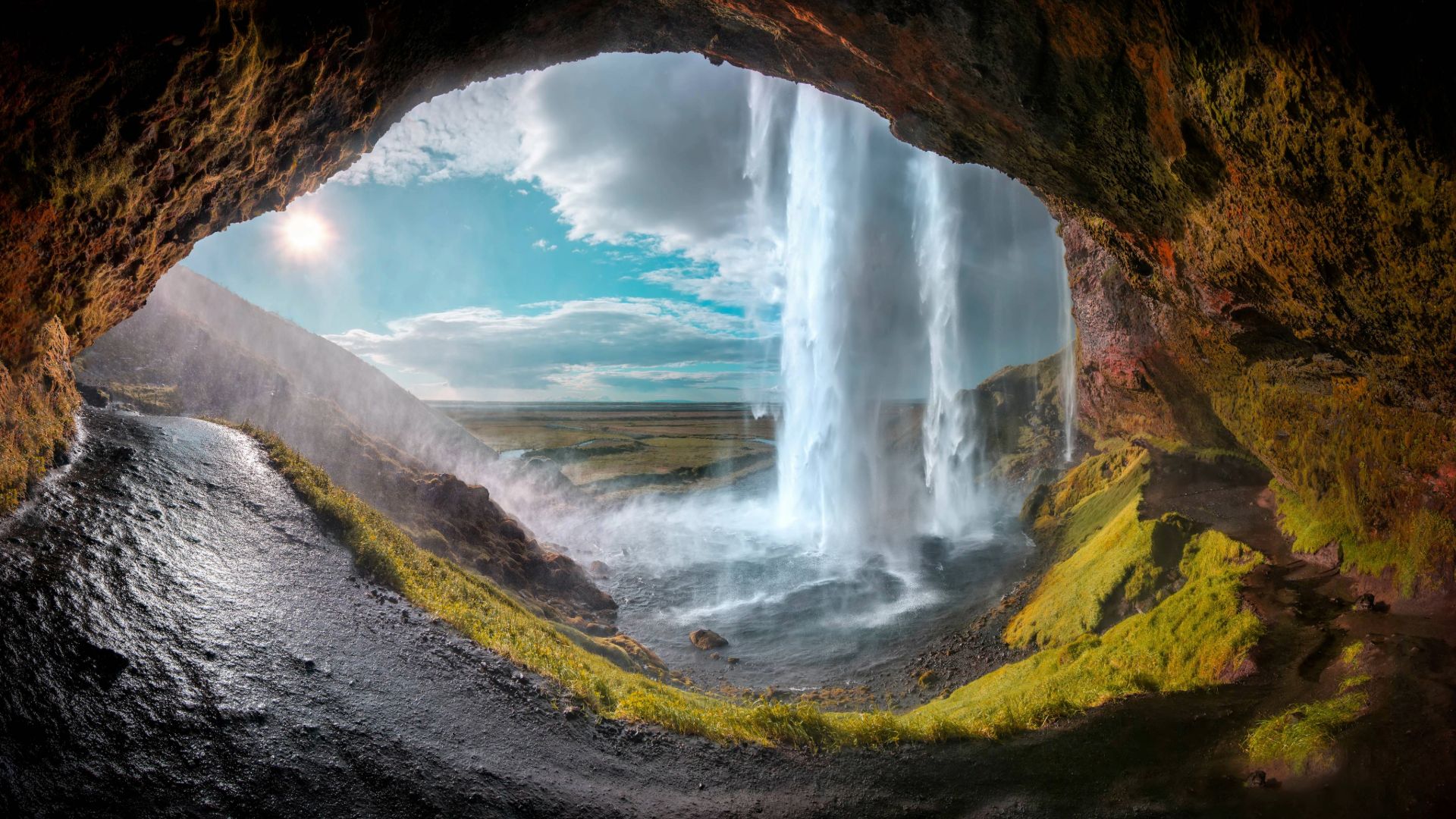 Seljalandsfoss waterfall viewed from behind inside cave Iceland